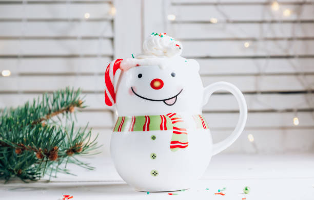 istock Hot chocolate in smiling snowman mug in Christmas setting 1285929789