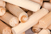 Pile of wooden dowel pins, close-up in selective focus