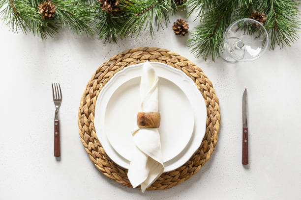 istock Christmas table setting with white holiday elegant decorations on white table. View from above. 1285930841