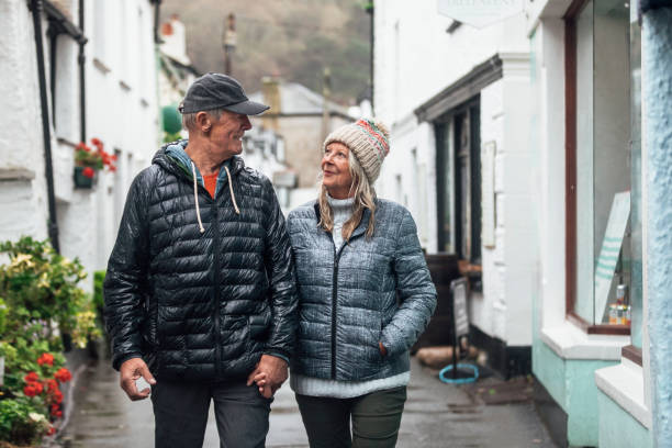 istock Senior Couple Strolling Through Town on a Rainy Day 1285932456