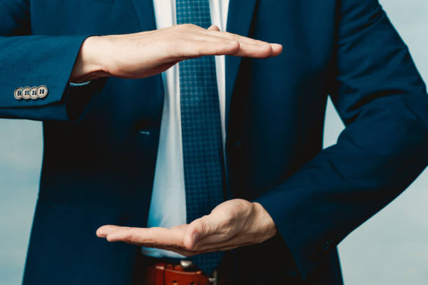 Hands of a man in a blue jacket folded in the shape of a sphere or as if pulling something. Hands of a man in a blue jacket folded in the shape of a sphere or as if pulling something male is standing and shows outstretched hand with open palm stock pictures, royalty-free photos & images