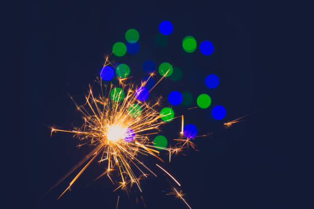 istock Bengal fire on a black background and blurred bokeh red lights (new year texture). 1285932552