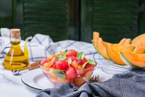 obstsalat mit melone cantaloupe, wassermelone und schinken - melon watermelon cantaloupe portion stock-fotos und bilder