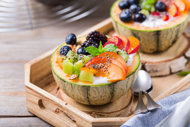 фруктовый салат с йогуртом в резной миску дыни cantaloupe - apricot portion antioxidant fruit стоковые фото и изображения