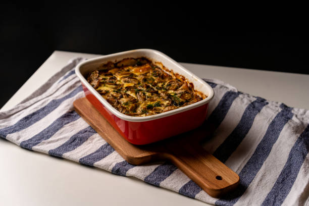 istock Mushroom julienne in a baking dish stands on a Board and on a kitchen towel on a white background 1285935651