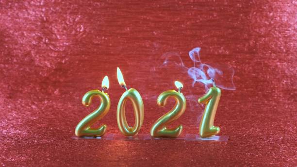 istock Extinct gold New Year's candles 2021 on red background. modern concept 1285937063