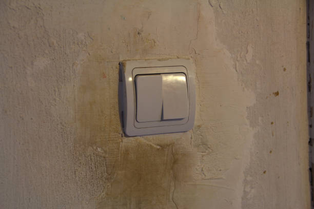 istock Dirty white light switch with dirty handprints on dirty white wall background 1285939436