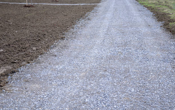 temporary gravel new dirt road. securing the slope against erosion at the door using brown jute fabric. stabilizing natural coconut mat for steep slopes. in heavy rain, the soil does not flush safety, growth, fixation, net, gardener, driveway, waterproof, material, vegetation, landscape, gravel road, exterior, broken stone, crushed rock, crushed, chip, rubble, sidewalk, surface, granite, roadside, country, stone, temporary, gravel, new, dirt, road, protective, protection, slope, erosion, door, brown, jute, fabric, stabilizing, natural, coconut, mat, steep, slopes, heavy, rain, soil flush, gray, lawn, park, garden, landscaped flushing water stock pictures, royalty-free photos & images