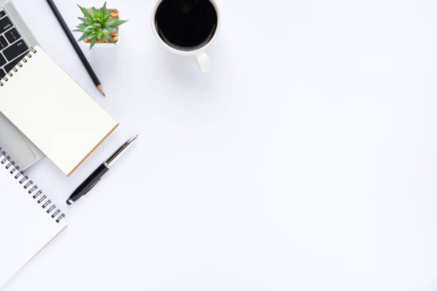 istock Top view above of White office desk table with keyboard, notebook and coffee cup with equipment other office supplies. Business and finance concept. Workplace, Flat lay with blank copy space. 1285942075