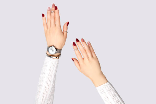 hermosas mujeres de la mano con una manicura rosa en estilo minimalista - female bracelet fotografías e imágenes de stock
