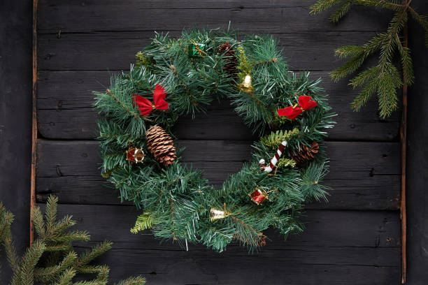 istock Christmas wreath on black wooden background 1285944015