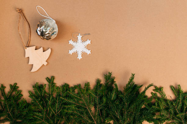 istock Christmas decorations flat layout with space for text. Fir branches on the cardboard background. Eco-friendly christmas ornaments. Wooden christmas tree in scandinavian style. 1285945092