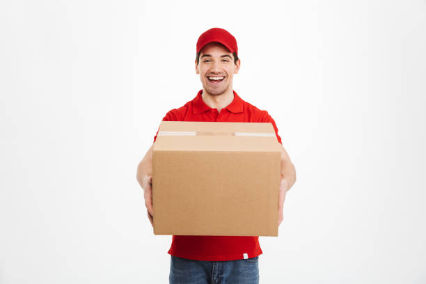 istock Excited happy young delivery man in red cap 1285945358