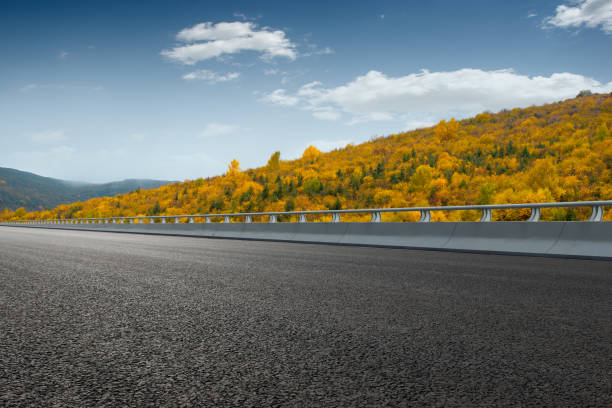 autunno, boschi dorati sul lato montano dell'autostrada, cina - road marking road reflector road dividing line foto e immagini stock