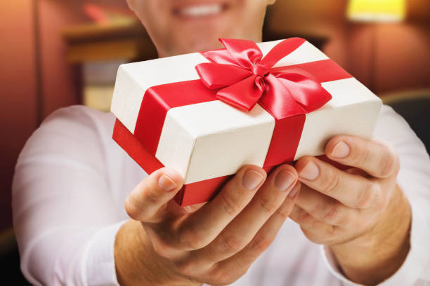 istock A man gives a gift for a holiday, close-up. Holidays concept 1285947044