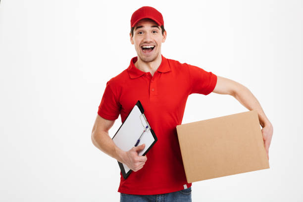 istock Excited happy young delivery man in red cap 1285947124