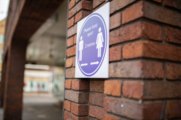 istock Sign on brick wall requesting people to keep a safe distance 1285947916