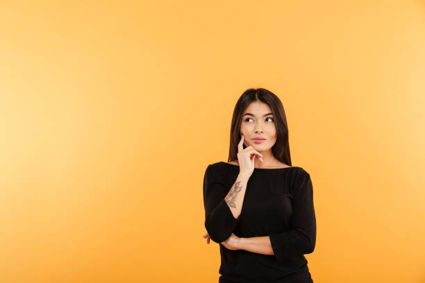 istock Thoughtful young woman standing isolated 1285949156
