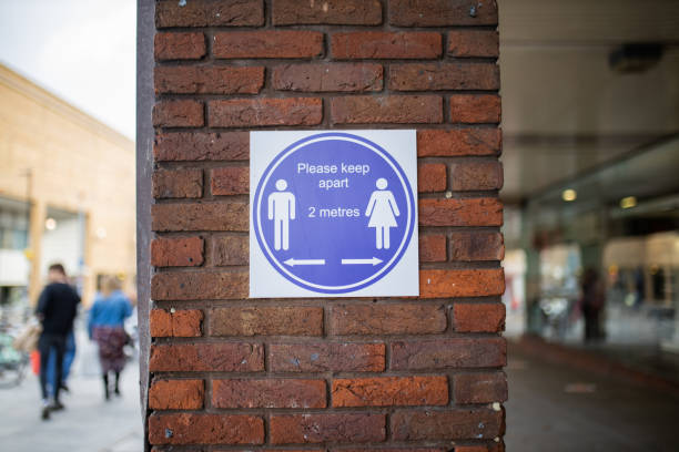 istock Sign on brick wall requesting people to keep a safe distance 1285949488
