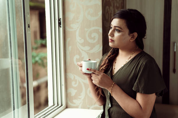 istock Thoughtful woman thinking and looking away while drinking hot tea or coffee 1285954160