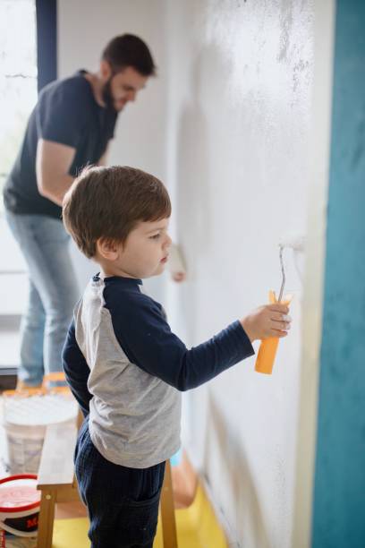 istock Father and son painting the walls 1285954564