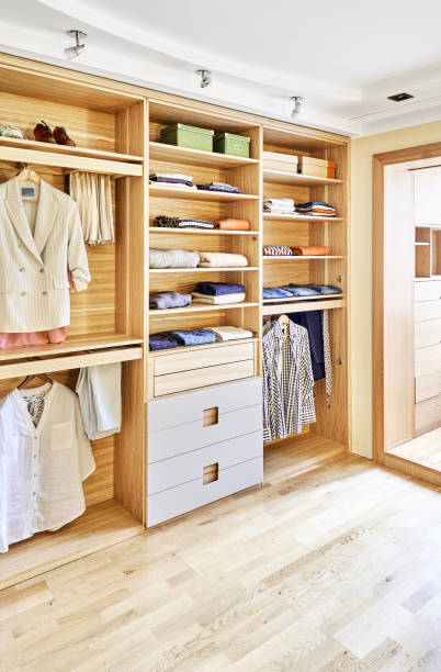 istock Modern wardrobe with clothes hanging on slide out racks and folded on the shelves. Modern furniture 1285957152