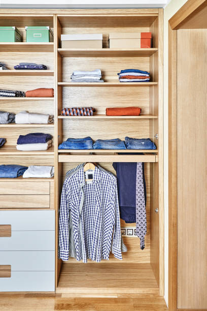 istock Modern wardrobe with clothes hanging on slide out racks and folded on the shelves. Modern furniture 1285957838