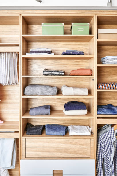 istock Modern wardrobe with clothes hanging on slide out racks and folded on the shelves. Modern furniture 1285958441