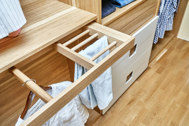 istock Modern wardrobe with clothes hanging on slide out racks and folded on the shelves. Modern furniture 1285958452