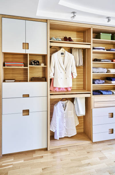 istock Modern wardrobe with clothes hanging on slide out racks and folded on the shelves. Modern furniture 1285958512