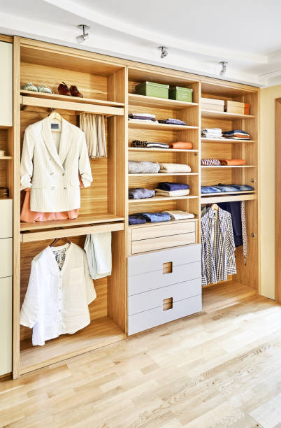 istock Modern wardrobe with clothes hanging on slide out racks and folded on the shelves. Modern furniture 1285958523