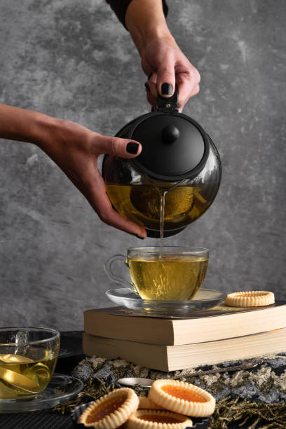 istock Woman hands pouring tea from  a teapot 1285959761