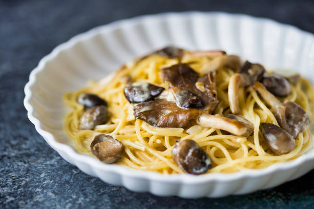 close up of plate of rustic italian spaghetti pasta in mushroom cream sauce