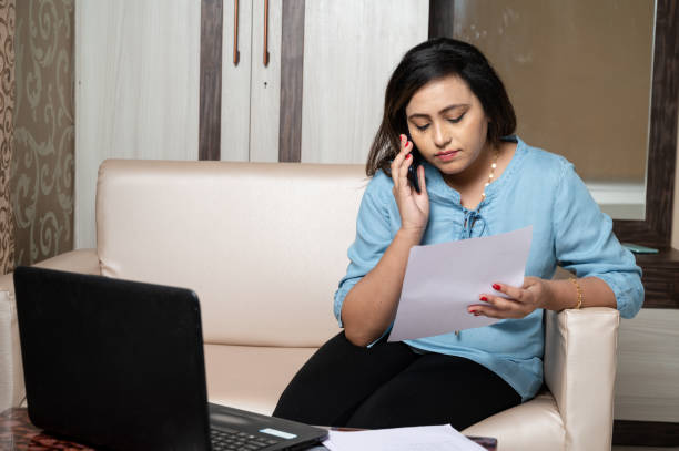 istock Frustrated woman using laptop and reading documents at home 1285960755