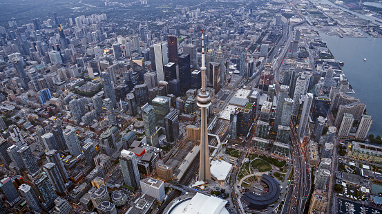 Aerial view of modern cityscape with CN Tower and Rogers Centre stadium at sunset, Toronto, Ontario, Canada.