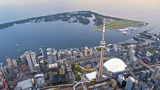 Aerial view of modern cityscape with CN Tower and Rogers Centre stadium at sunset, Toronto, Ontario, Canada.