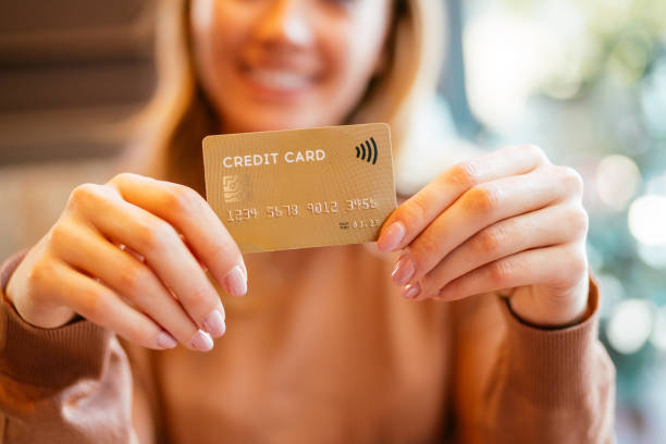 istock Woman holding a credit card 1285963579