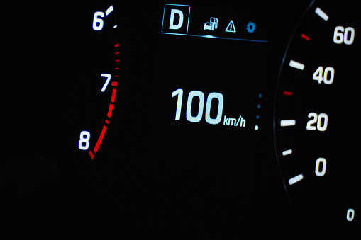 Speedometer in the car on the dashboard. The car's speedometer shows 100 mph