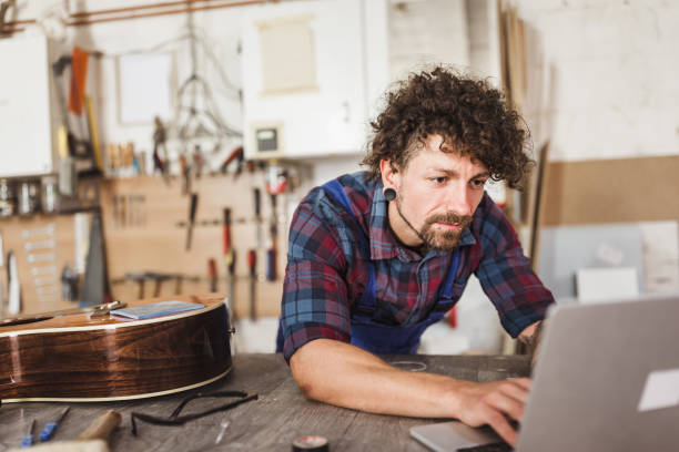 istock Manual worker repairing acoustic guitar at his workshop 1285965425
