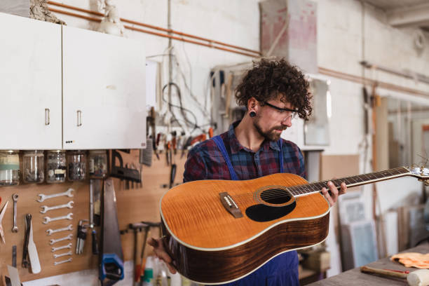 istock Manual worker repairing acoustic guitar at his workshop 1285965438