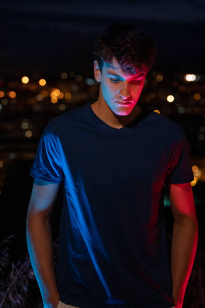 istock Young man with city lights at background 1285965707