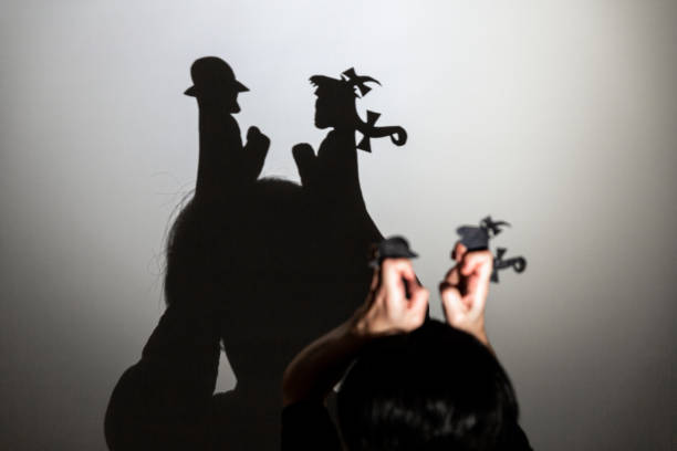 istock play shadow projected against a white background. two little people 1285966239