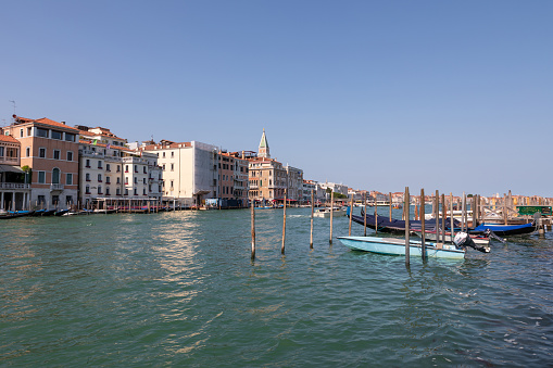 Venice, Italy - July 1, 2018: Panoramic view of Grand Canal (Canal Grande) with active traffic boats. It is a major water-traffic corridors in Venice city. Landscape of summer sunny day and blue sky