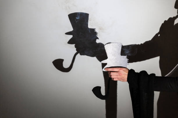 istock play shadow projected against a white background. a old man with hat. 1285967276