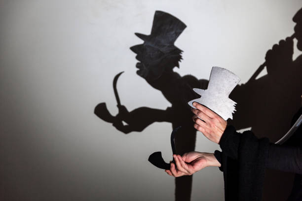 istock play shadow projected against a white background. a old man with hat. 1285967322