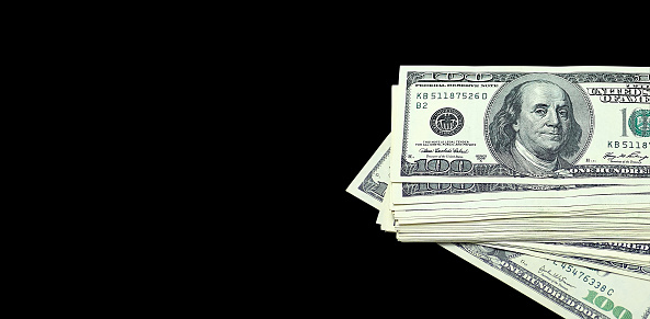 Stack of one hundred dollar bills isolated on black background