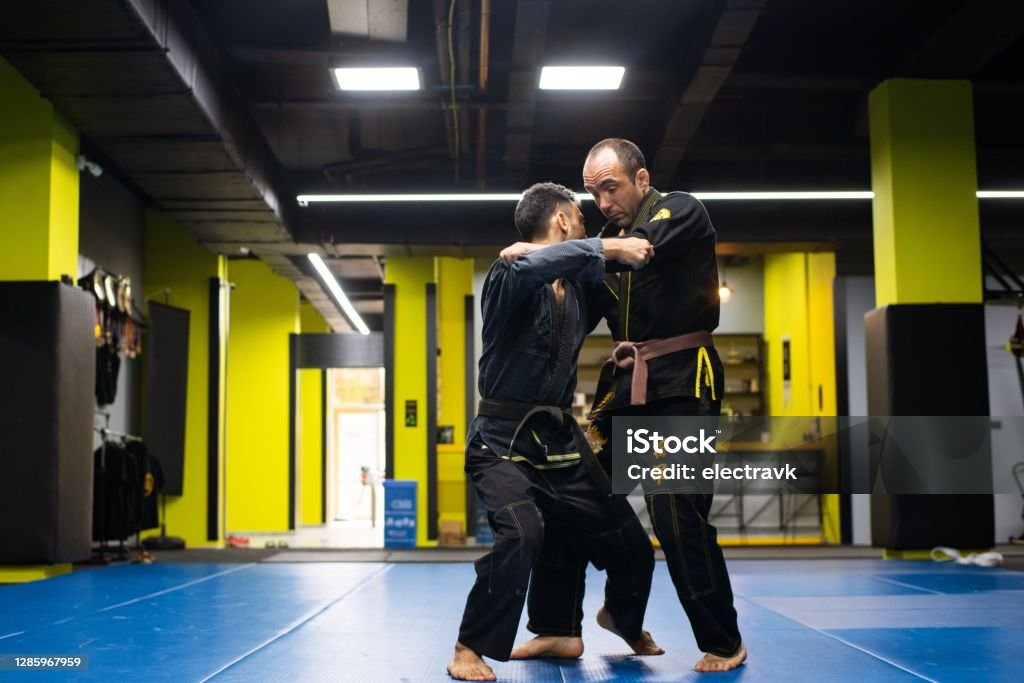 Martial arts athletes training Two professional athletes working on judo and BJJ techniques in gi. Jujitsu Stock Photo