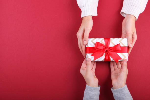 istock Two pairs of hands and a shot on a colored background top view 1285968038