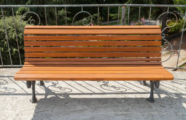 istock Empty wooden bench stands near metal railings 1285968366