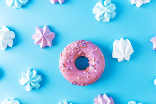 istock Pink, blue and merengue cookies with pink donut on a blue background 1285969546